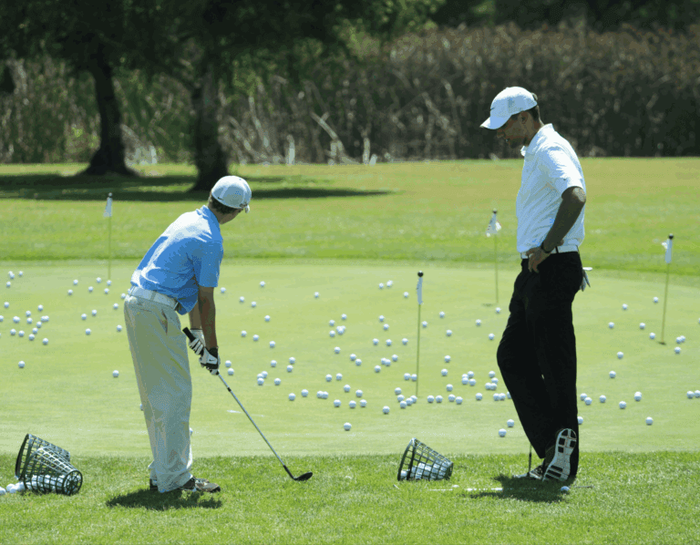 a junior golfer being coached during practise