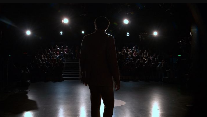man on dark presentation stage