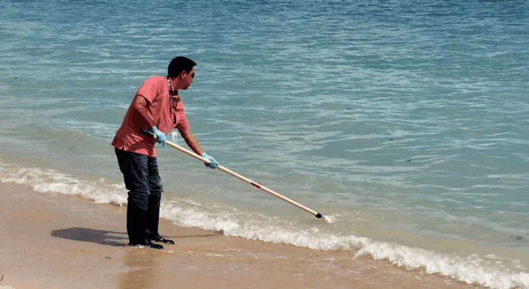 a man sweeping the tide with a broom
